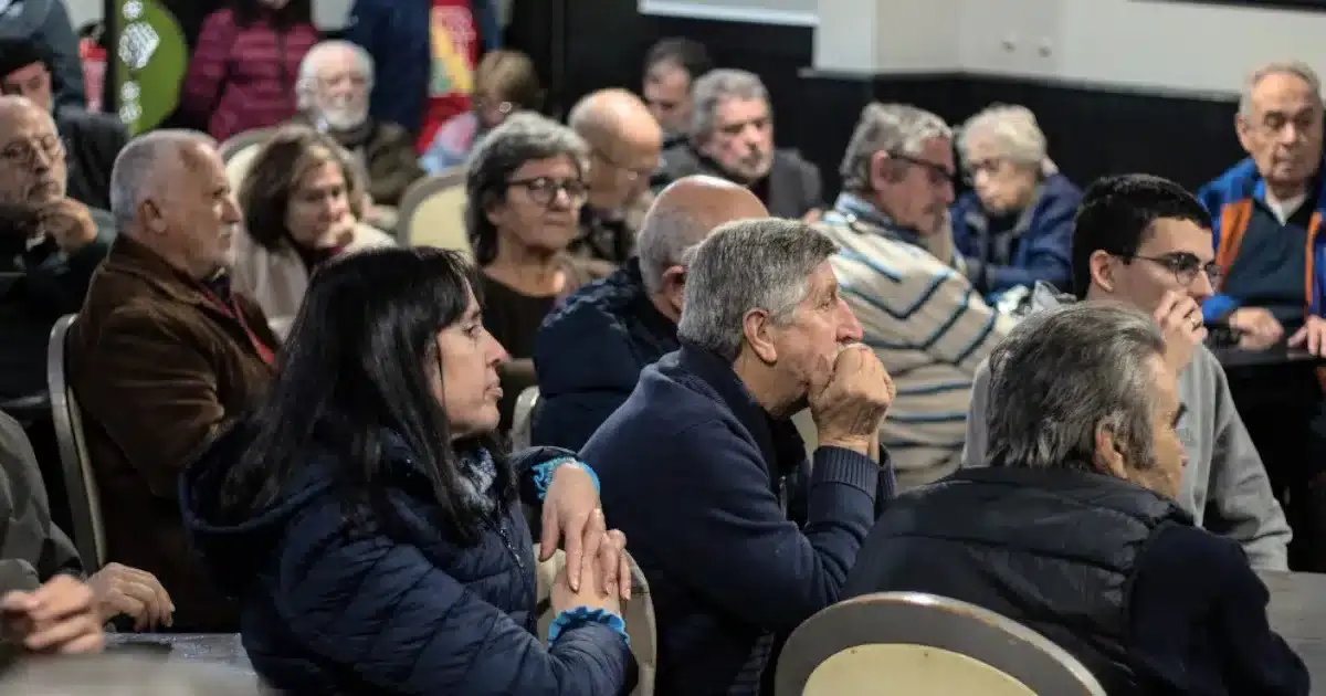 Público assistindo palestra em ambiente fechado.