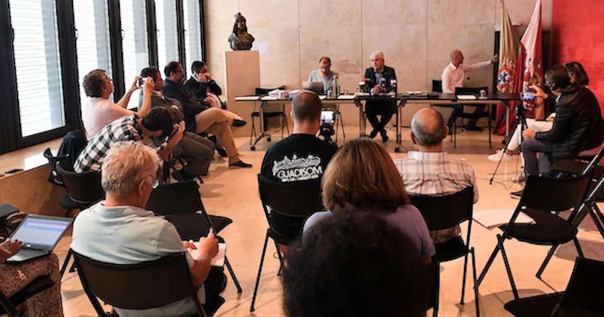 Conferência com oradores e público sentado.