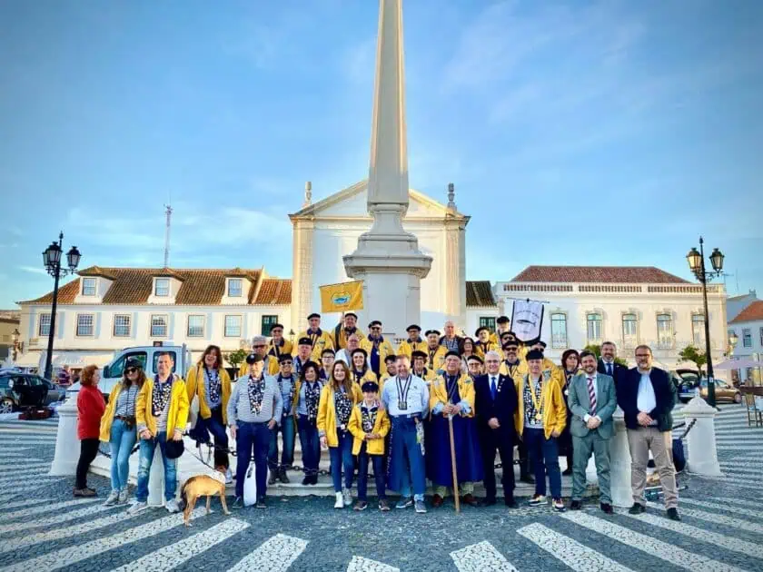 Grupo de pessoas com lenços amarelos, praça histórica.