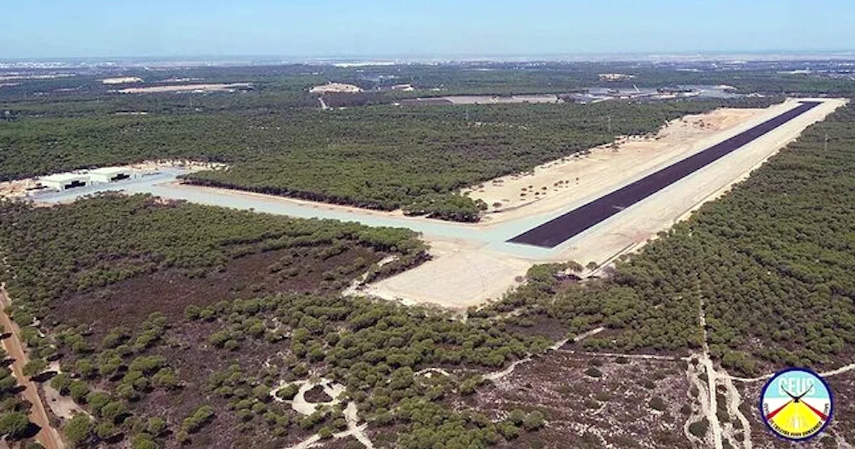 Pista de aeroporto rodeada por floresta vista de cima.