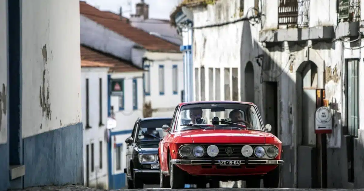 Carro clássico vermelho em rua antiga.