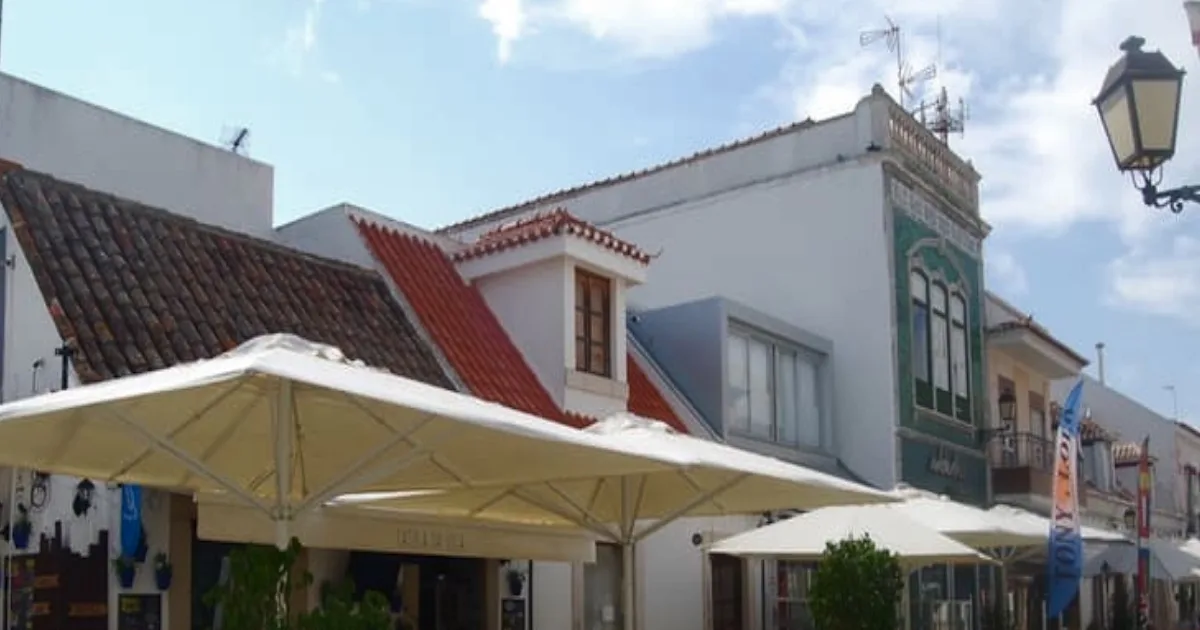 Esplanada em rua tradicional portuguesa com edifícios históricos.