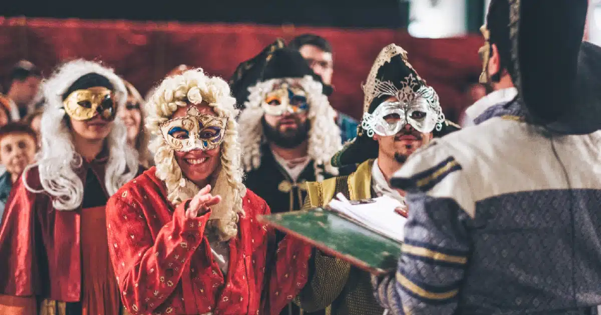 Pessoas em trajes de época com máscaras venezianas.